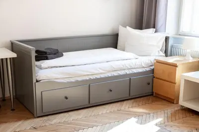 a bed with white sheets on it in a room at Apartments in Mala Strana - 10 minutes from Charles Bridge in Prague