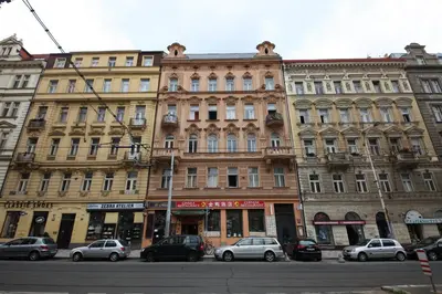 a large building with cars parked in front of it at Apartments in Mala Strana - 10 minutes from Charles Bridge in Prague