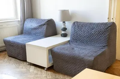 a living room with a chair and a table and a lamp at Apartments in Mala Strana - 10 minutes from Charles Bridge in Prague