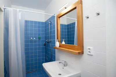 a blue tiled bathroom with a sink and a mirror at Žižkov Cosy Studio Apartments in Prague