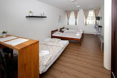 a room with two beds and a desk at Žižkov Cosy Studio Apartments in Prague