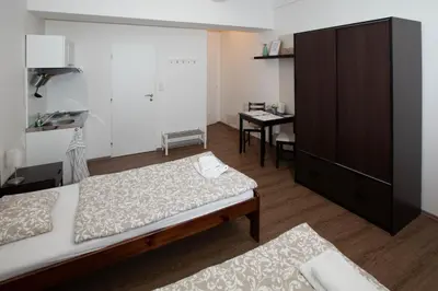 a hotel room with two beds and a desk at Žižkov Cosy Studio Apartments in Prague