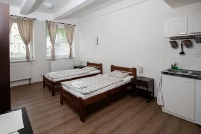 a room with two beds in it with a kitchen at Žižkov Cosy Studio Apartments in Prague