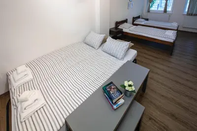 a living room with two beds and a table at Žižkov Cosy Studio Apartments in Prague