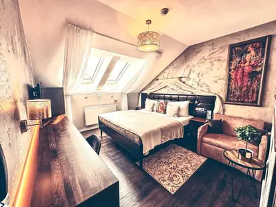 a bedroom with a bed and a couch and a window at Alfons Boutique Hotel in Prague