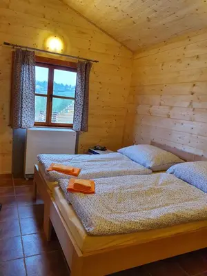 a bedroom with two beds in a log cabin at Sport-hotel Šibeniční vrch in Mnichovice