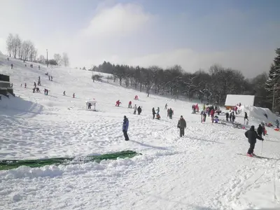 a group of people skiing down a snow covered slope at Sport-hotel Šibeniční vrch in Mnichovice