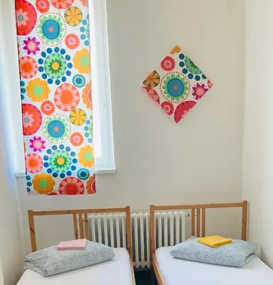 two beds in a room with a painting on the wall at Hostel Praha Ládví in Prague