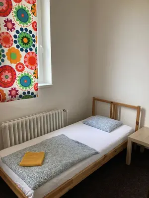 a bed in a room with a painting on the wall at Hostel Praha Ládví in Prague
