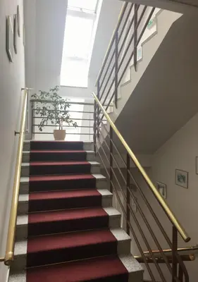 a staircase with red and white carpet and a window at Hotel Otar in Prague