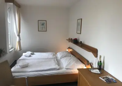 a bed with white sheets and pillows in a bedroom at Hotel Otar in Prague