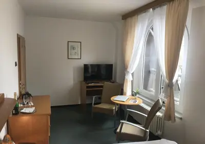 a hotel room with a table and a window at Hotel Otar in Prague
