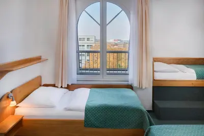 two beds in a room with a window at Hotel Otar in Prague