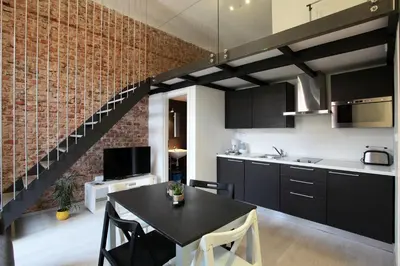 a kitchen with a black table and a brick wall at Apartment House - The Modern Flat in Prague
