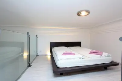 a bedroom with a bed with pink pillows on it at Apartment House - The Modern Flat in Prague