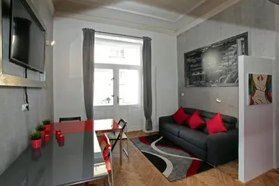 a living room with a black couch and red pillows at Apartment House - The Modern Flat in Prague