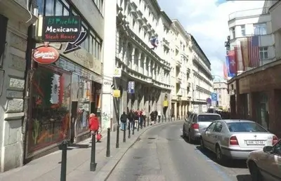 a person riding a bike down a city street with buildings at Apartment House - The Modern Flat in Prague