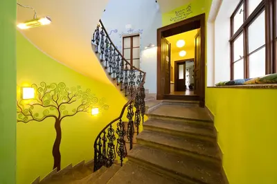 a staircase in a house with a tree painted on the wall at Hostel Orange in Prague