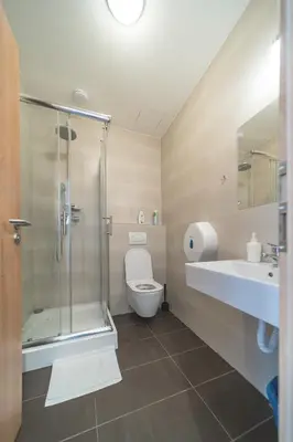 a bathroom with a shower and a toilet and a sink at Hostel Orange in Prague
