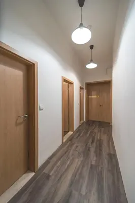 an empty hallway with wood floors and doors at Hostel Orange in Prague
