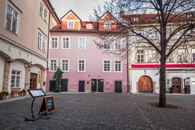 a large pink building with a sign in front of it at Tyn Yard Residence in Prague