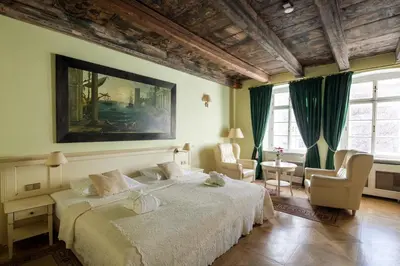 a bedroom with a large bed and two chairs at Tyn Yard Residence in Prague