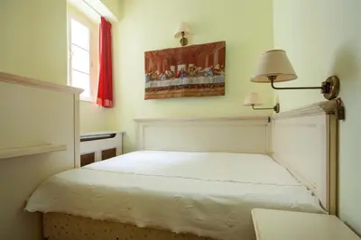 a bedroom with a bed with a lamp and a painting at Tyn Yard Residence in Prague