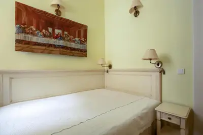a white bed in a room with a painting on the wall at Tyn Yard Residence in Prague