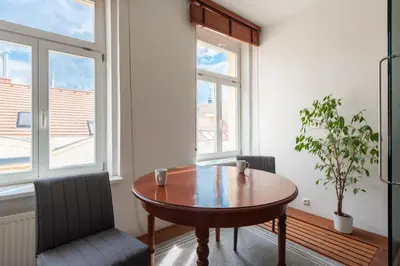 a dining room with a wooden table and two chairs at Modern apartment few steps from centre in Prague