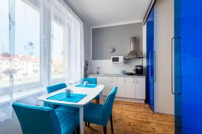 a kitchen with a white table and blue chairs at Bright apartment few steps from centre in Prague