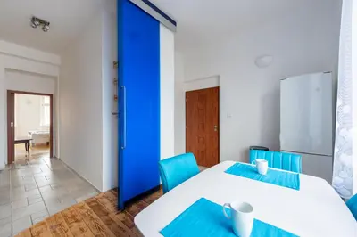 a room with two tables and a blue door at Bright apartment few steps from centre in Prague