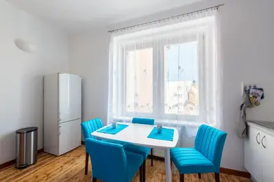 a kitchen with a white table and blue chairs at Bright apartment few steps from centre in Prague