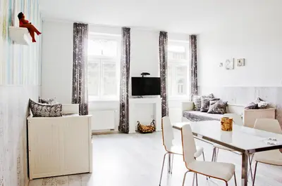a white living room with a table and chairs at Royal Court Legerova in Prague