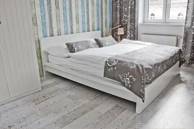 a white bed in a room with a window at Royal Court Legerova in Prague