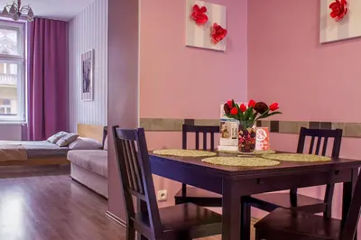 a dining room with a table with red flowers on it at Royal Court Legerova in Prague