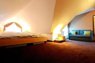 a hotel room with a bed with white sheets at Hotel Zámek Berchtold in Kunice - Vidovice
