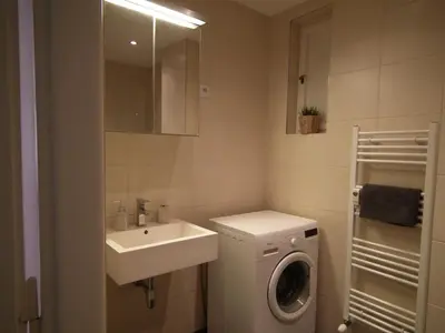 a small bathroom with a washing machine and a sink at Old Town spacious apartment in Prague