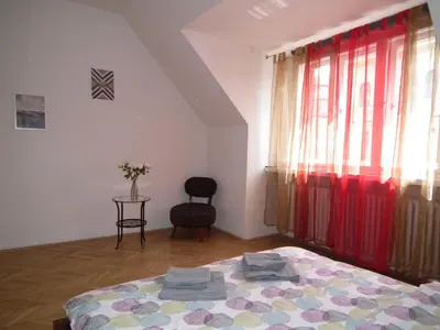 a bedroom with a bed and a chair and a window at Old Town spacious apartment in Prague