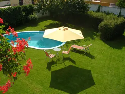 an umbrella and chairs next to a swimming pool at Fontána in Prague