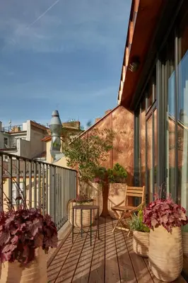 a balcony with potted plants and a table and chairs at The Emerald in Prague