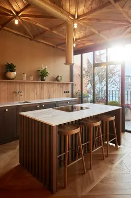 a kitchen with a large kitchen island with bar stools at The Emerald in Prague
