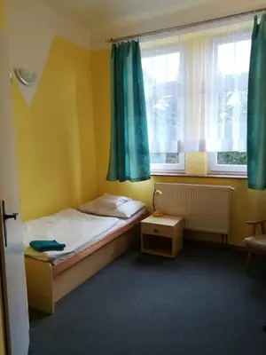 a small bedroom with a bed and a window at Hotel Modrá hvězda Sadská in Sadská