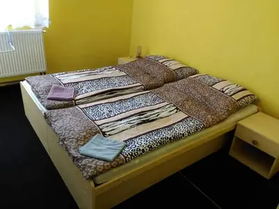 a bed with a comforter on it in a room at Hotel Modrá hvězda Sadská in Sadská