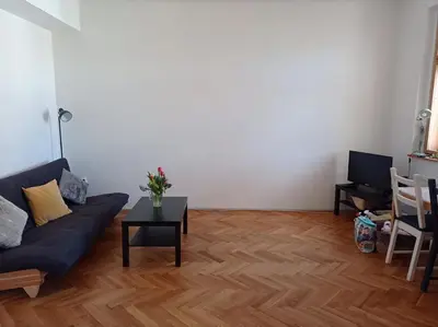 a living room with a blue couch and a table at Big family apartment in Prague