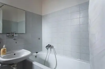 a white bathroom with a sink and a tub and a sink at Big family apartment in Prague