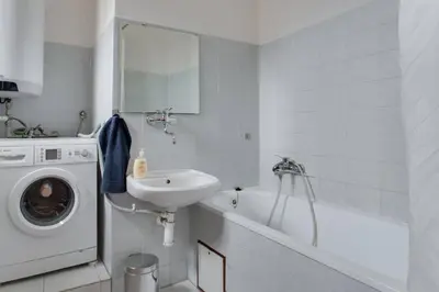 a bathroom with a sink and a washing machine at Big family apartment in Prague