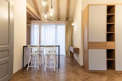 a kitchen and dining room with a table and stools at Wishlist Prague Residences - Vinohrady in Prague
