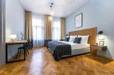 a hotel room with a bed and a desk and a desk at Wishlist Prague Residences - Vinohrady in Prague