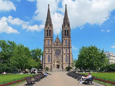 a church with people sitting on benches in front of it at Wishlist Prague Residences - Vinohrady in Prague