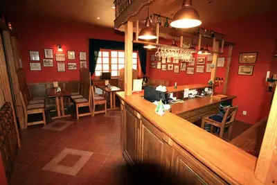 a bar in a restaurant with red walls at Penzion Coupe in Příbram